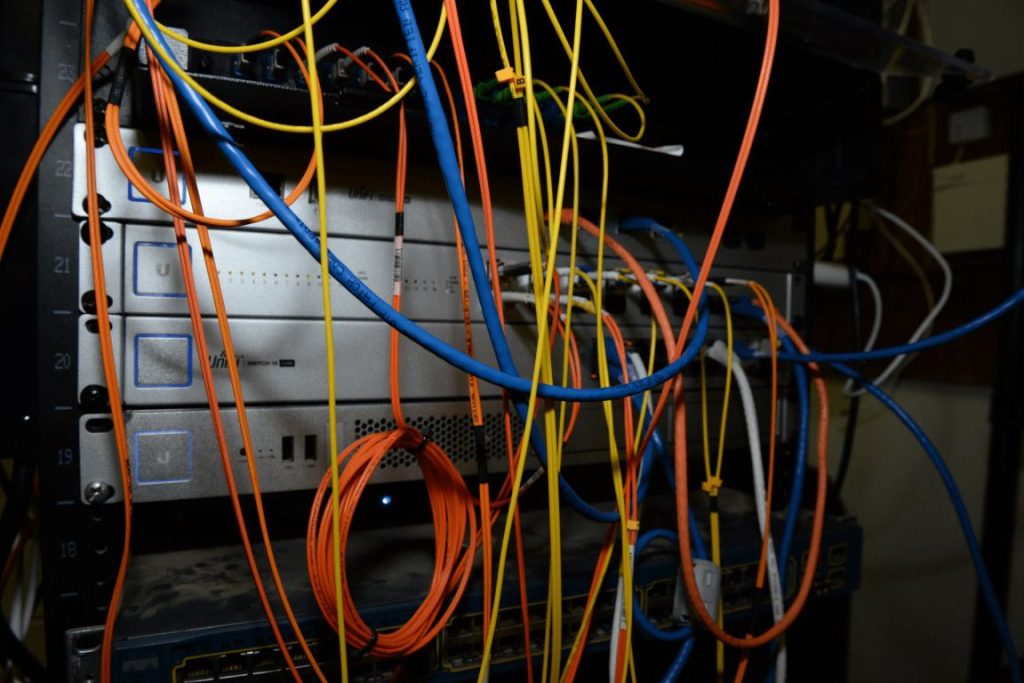 Rows of blue network cables connect servers inside a modern data centre room.