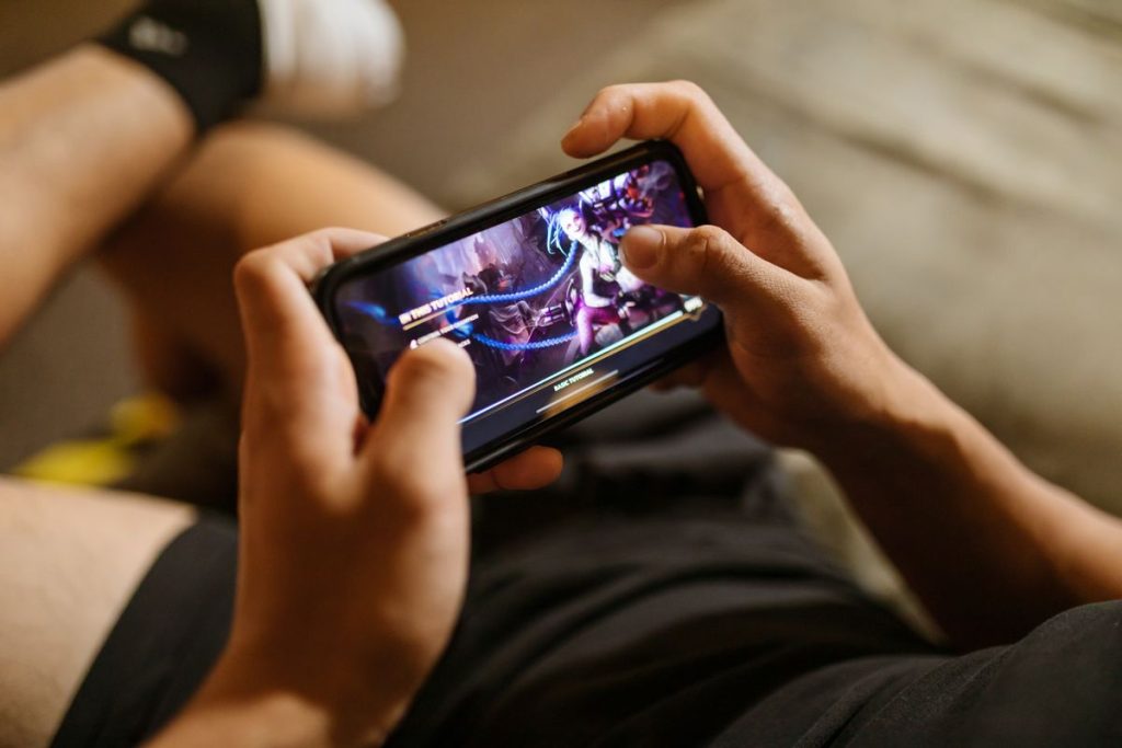 NAGAPETIR Login: How to Access Your Account Safely and Easily Close-up of hands holding a smartphone playing a mobile game